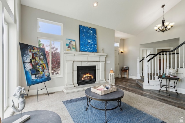 1001 E 1500 N, Layton, UT 84040 - living room featuring stairway, a chandelier, a glass covered fireplace, high vaulted ceiling, and baseboards