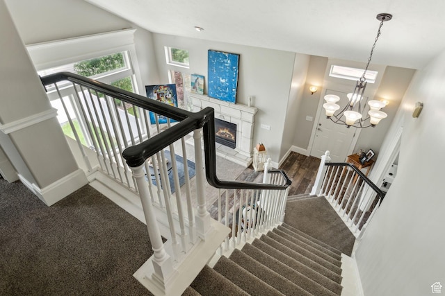 1001 E 1500 N, Layton, UT 84040 - staircase featuring baseboards, a glass covered fireplace, carpet flooring, and a chandelier