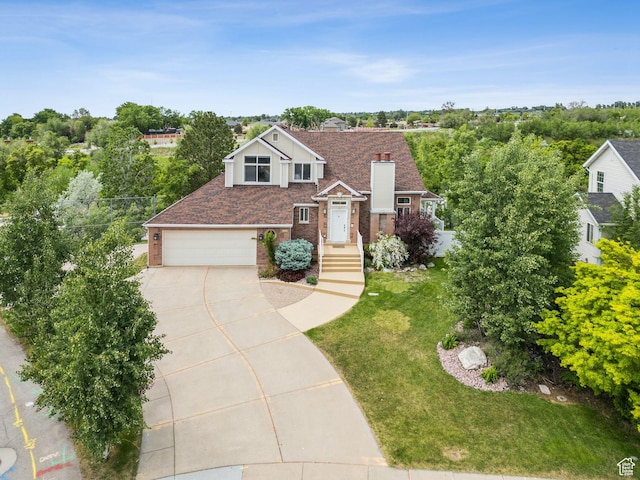 1001 E 1500 N, Layton, UT 84040 - view of front of home with concrete driveway, brick siding, a front yard, a chimney, and an attached garage