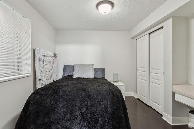 1001 E 1500 N, Layton, UT 84040 - bedroom with finished concrete floors, a textured ceiling, a closet, and baseboards