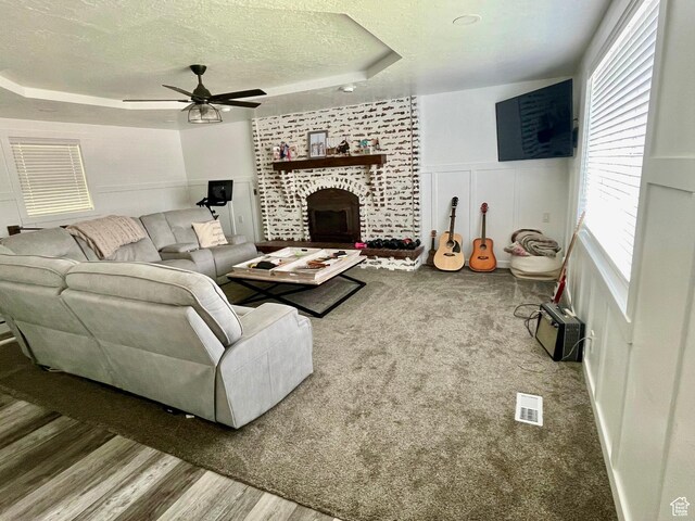 229 N 300 W, Salina, UT 84654 - living room featuring a textured ceiling, a tray ceiling, a ceiling fan, a decorative wall, and healthy amount of natural light