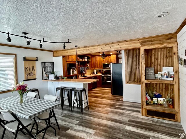 229 N 300 W, Salina, UT 84654 - dining space with a textured ceiling, rail lighting, ornamental molding, wooden walls, and dark wood-style floors