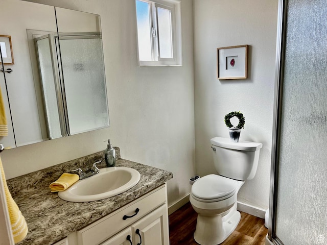 1150 W Red Hills Pkwy Unit 140, Washington, UT 84780 - bathroom featuring vanity, a stall shower, baseboards, toilet, and wood finished floors