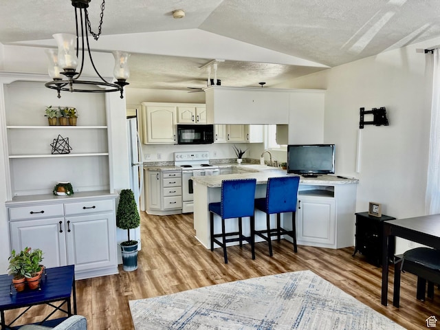 1150 W Red Hills Pkwy Unit 140, Washington, UT 84780 - kitchen featuring black microwave, white electric stove, a sink, a peninsula, and lofted ceiling