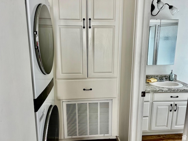 1150 W Red Hills Pkwy Unit 140, Washington, UT 84780 - laundry room featuring stacked washer / dryer and cabinet space