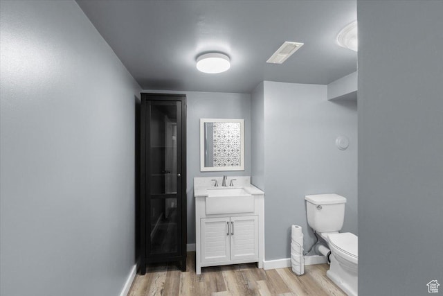131 N 100 W, Hyrum, UT 84319 - bathroom featuring wood finished floors, toilet, vanity, and baseboards