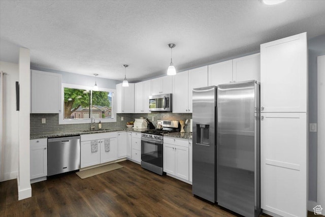 131 N 100 W, Hyrum, UT 84319 - kitchen featuring appliances with stainless steel finishes, a sink, backsplash, dark wood-type flooring, and a textured ceiling