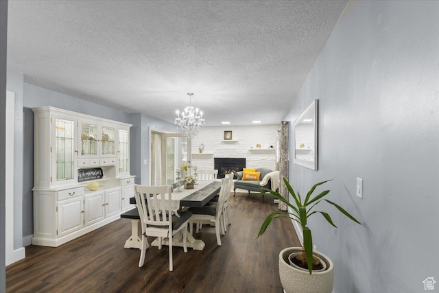 131 N 100 W, Hyrum, UT 84319 - dining room featuring a chandelier, dark wood-style floors, a textured ceiling, a fireplace, and baseboards