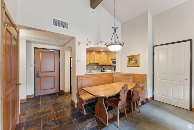 840 Bigler Ln Unit 3031, Midway, UT 84049 - dining area featuring high vaulted ceiling, baseboards, arched walkways, dark stone finish flooring, and beamed ceiling