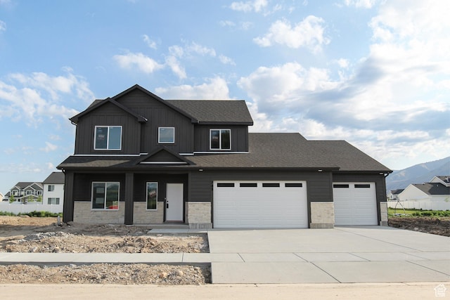 743 E 1250 S, Hyrum, UT 84319 - view of front of home featuring concrete driveway, an attached garage, stone siding, and a mountain view