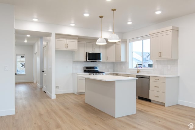 743 E 1250 S, Hyrum, UT 84319 - kitchen with appliances with stainless steel finishes, a kitchen island, light wood-style floors, tasteful backsplash, and recessed lighting