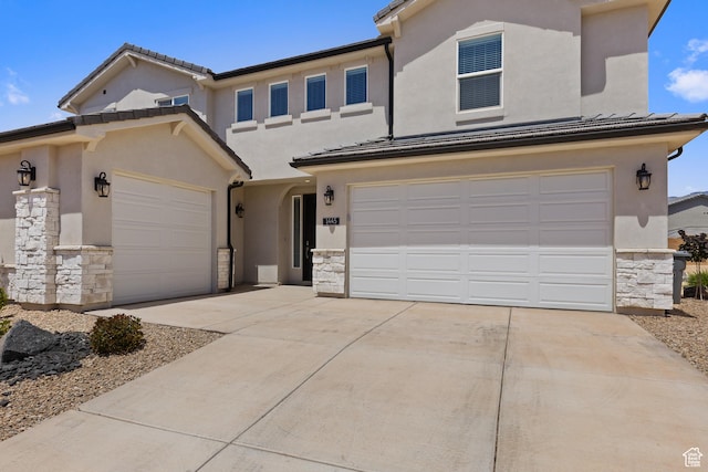 1445 N Arena Roja Dr, Washington, UT 84780 - view of front of home featuring stone siding, driveway, an attached garage, and stucco siding