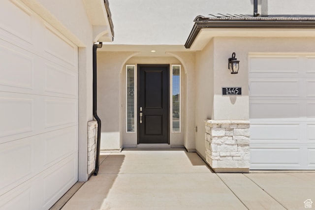 1445 N Arena Roja Dr, Washington, UT 84780 - doorway to property with stucco siding, a garage, and stone siding