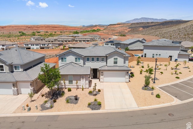 1445 N Arena Roja Dr, Washington, UT 84780 - view of front facade with a residential view, an attached garage, driveway, stucco siding, and a mountain view