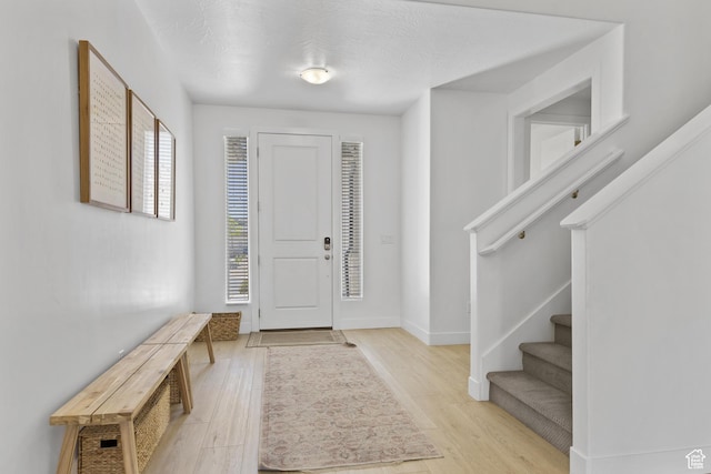 1445 N Arena Roja Dr, Washington, UT 84780 - entrance foyer with stairway, light wood-style floors, and baseboards