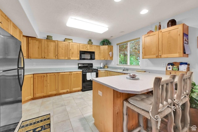 1076 E Creekside, Ogden, UT 84404 - kitchen featuring black appliances, a peninsula, light countertops, a kitchen breakfast bar, and a sink