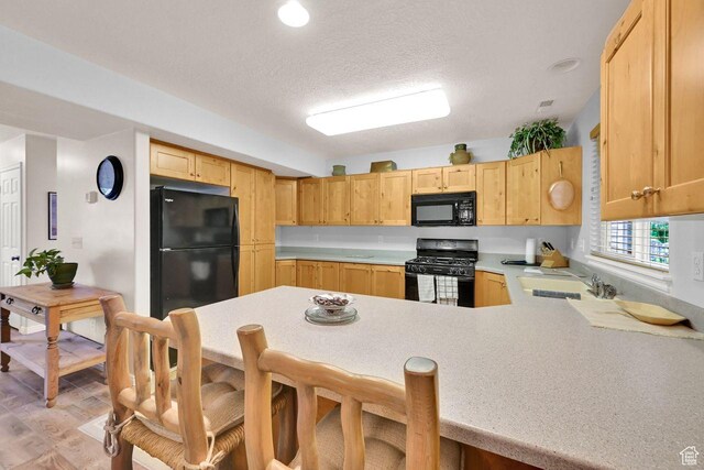1076 E Creekside, Ogden, UT 84404 - kitchen with black appliances, a sink, light countertops, a peninsula, and light brown cabinetry