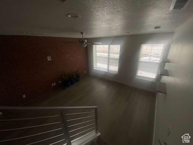 5841 W Lake Ave, South Jordan, UT 84009 - spare room with a textured ceiling, wood finished floors, a ceiling fan, and brick wall