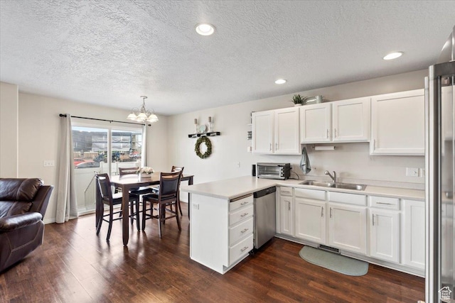 1298 S 1410 E, Provo, UT 84606 - kitchen featuring appliances with stainless steel finishes, a sink, a peninsula, a chandelier, and white cabinets