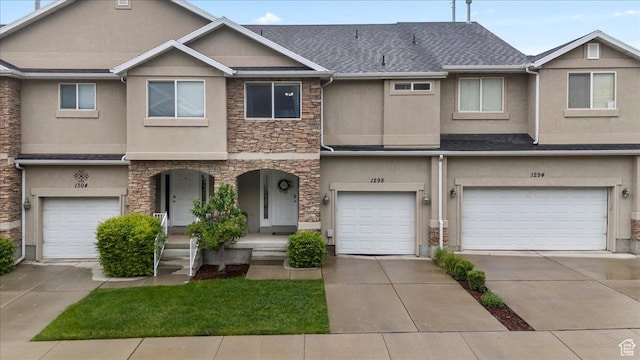 1298 S 1410 E, Provo, UT 84606 - townhome / multi-family property featuring stone siding, stucco siding, an attached garage, covered porch, and driveway