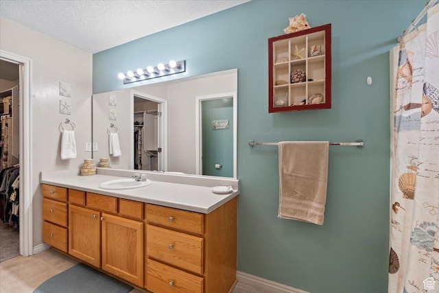 1298 S 1410 E, Provo, UT 84606 - full bathroom with a walk in closet, vanity, a textured ceiling, and tile patterned floors