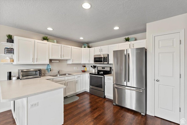 1298 S 1410 E, Provo, UT 84606 - kitchen featuring appliances with stainless steel finishes, a peninsula, a sink, light countertops, and white cabinets