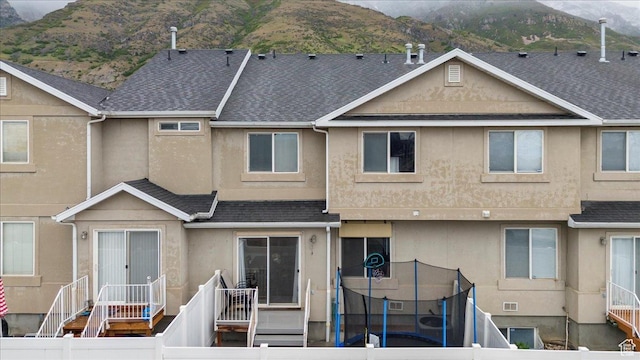 1298 S 1410 E, Provo, UT 84606 - back of house with stucco siding, a mountain view, a shingled roof, and a trampoline