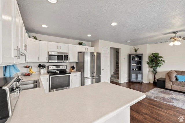 1298 S 1410 E, Provo, UT 84606 - kitchen with appliances with stainless steel finishes, open floor plan, light countertops, dark wood-style floors, and white cabinets