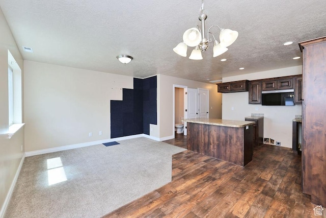 1852 E Whitetail Dr N Unit 106, Layton, UT 84040 - kitchen with a chandelier, black microwave, a center island, dark brown cabinets, and a textured ceiling