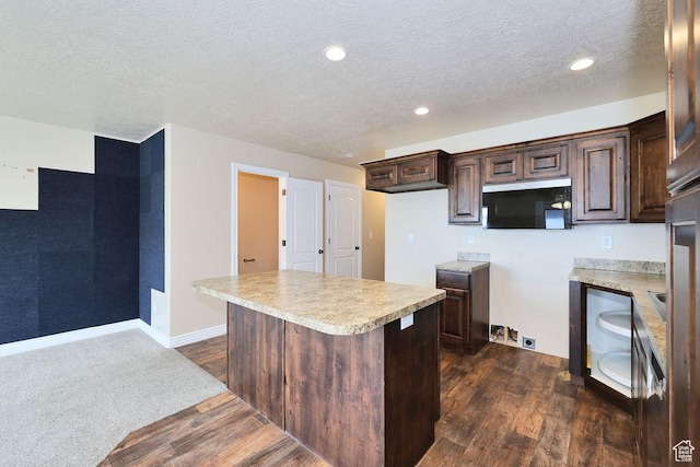 1852 E Whitetail Dr N Unit 106, Layton, UT 84040 - kitchen with stainless steel microwave, dark brown cabinets, dark wood-type flooring, a textured ceiling, and light countertops