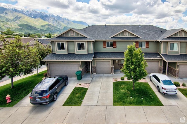 1852 E Whitetail Dr N Unit 106, Layton, UT 84040 - view of front of home with an attached garage, a mountain view, driveway, roof with shingles, and a front yard