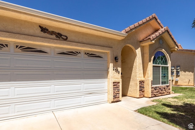 2578 W 225 N, Hurricane, UT 84737 - view of front of house featuring concrete driveway, stucco siding, a garage, a tile roof, and stone siding