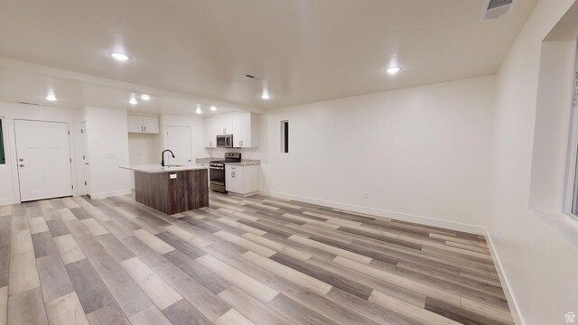 920 S 25 E # 18E, Cedar City, UT 84720 - kitchen featuring appliances with stainless steel finishes, a sink, recessed lighting, baseboards, and a center island with sink