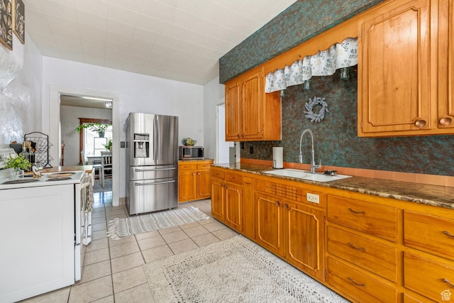 212 E 100 S, Payson, UT 84651 - kitchen with appliances with stainless steel finishes, a sink, brown cabinets, light tile patterned floors, and wallpapered walls