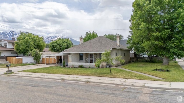 212 E 100 S, Payson, UT 84651 - view of front of house featuring driveway, brick siding, a chimney, a mountain view, and roof with shingles