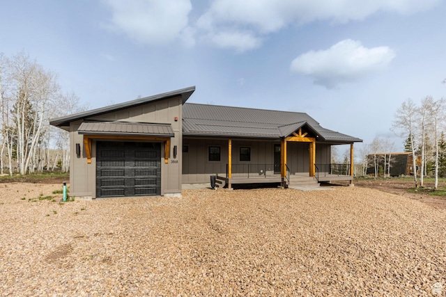 view of front of home featuring board and batten siding, an attached garage, covered porch, and driveway