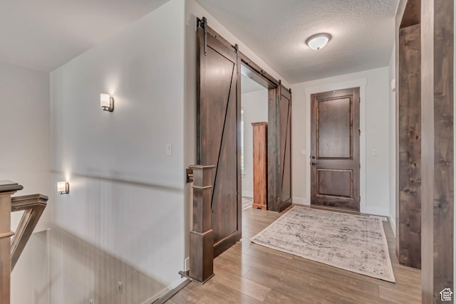487 W 500 N, Mapleton, UT 84664 - entrance foyer featuring a barn door, light wood-style flooring, baseboards, and a textured ceiling