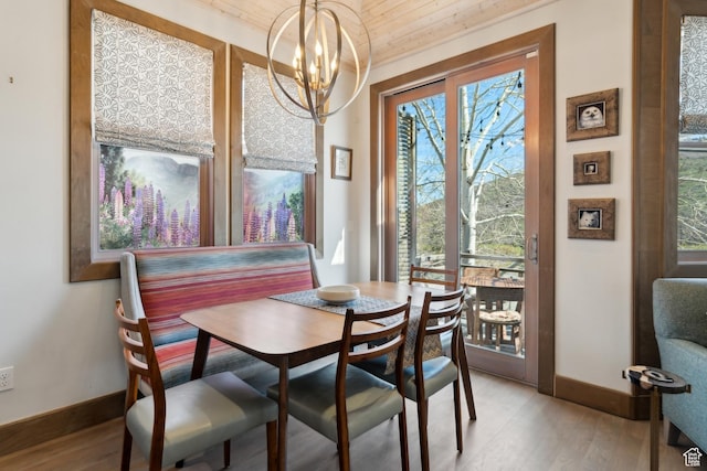 dining space with baseboards, light wood-style floors, a chandelier, and wooden ceiling