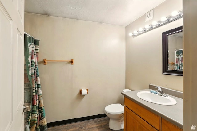 3703 W 600 S, Logan, UT 84321 - bathroom featuring toilet, vanity, wood finished floors, and a textured ceiling
