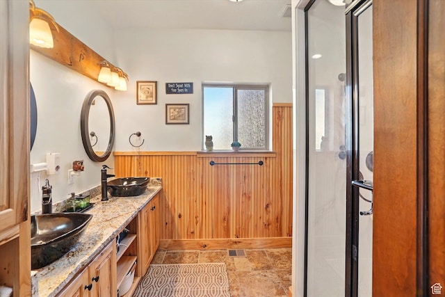 3703 W 600 S, Logan, UT 84321 - full bathroom with a stall shower, wainscoting, wood walls, and double vanity