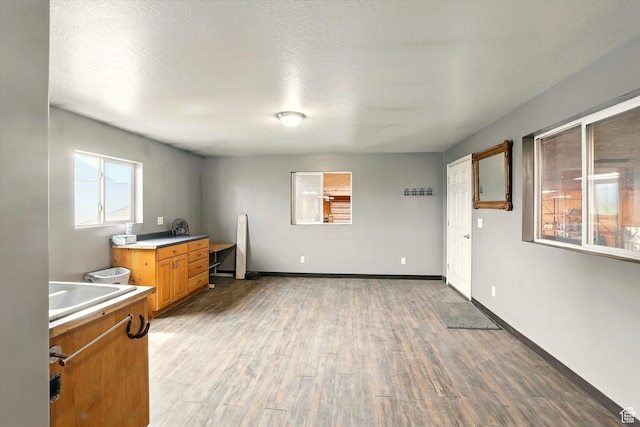 3703 W 600 S, Logan, UT 84321 - kitchen featuring light wood-style floors, light countertops, brown cabinetry, a sink, and baseboards