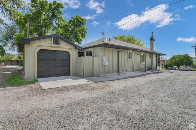225 S 900 E, Salt Lake City, UT 84102 - ranch-style house with board and batten siding, a garage, an outbuilding, concrete driveway, and fence