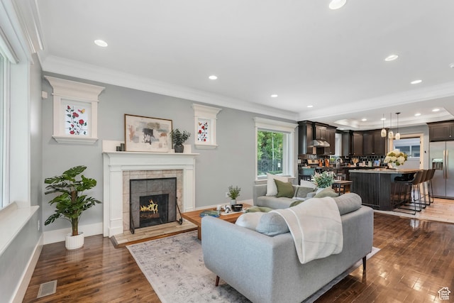 225 S 900 E, Salt Lake City, UT 84102 - living room featuring dark wood-style flooring, crown molding, a tiled fireplace, recessed lighting, and baseboards