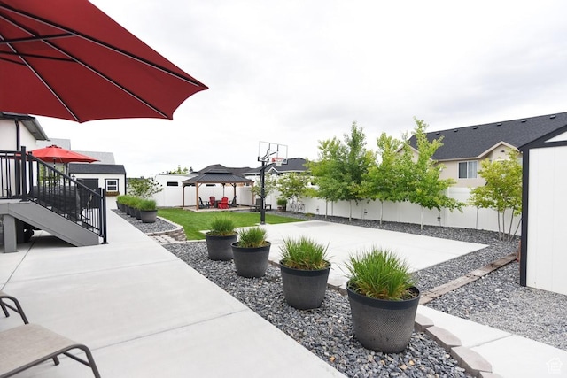 view of patio / terrace featuring a gazebo, a fenced backyard, a residential view, and stairs