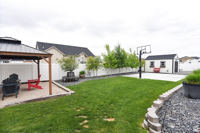 view of yard with a gazebo, an outdoor fire pit, a patio area, and an outbuilding