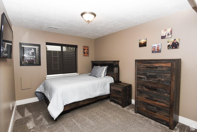 carpeted bedroom featuring baseboards and a textured ceiling