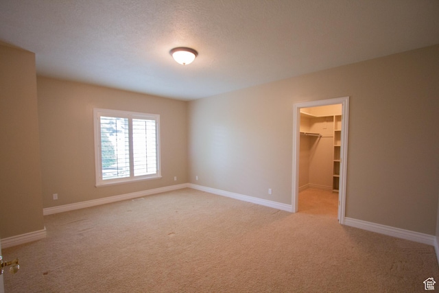 1315 E 1550 N, North Logan, UT 84341 - unfurnished bedroom with light colored carpet, a walk in closet, baseboards, and a closet