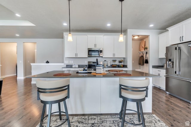 701 S Crooket Post Way W, Saratoga Springs, UT 84045 - kitchen with appliances with stainless steel finishes, dark countertops, wood finished floors, a breakfast bar, and recessed lighting