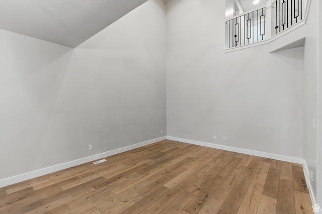 additional living space with wood-type flooring, baseboards, and lofted ceiling