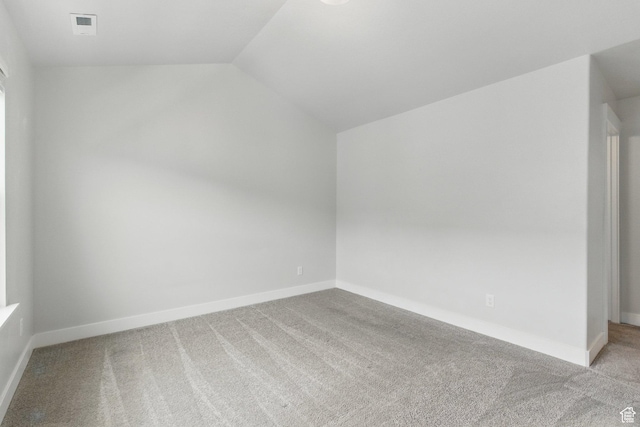 additional living space with carpet floors, lofted ceiling, and baseboards